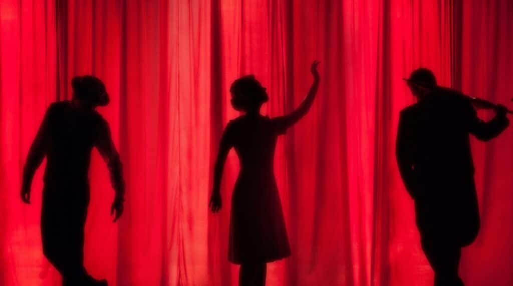 Behind a red curtain the outline of three people for the Festivals In Kent 2023 - Theatre, Arts & Crafts blog post