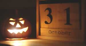 Scary lit pumpkin next to wooden block with 31 October on it. For Halloween In Kent 2023 - Adult Events blog post