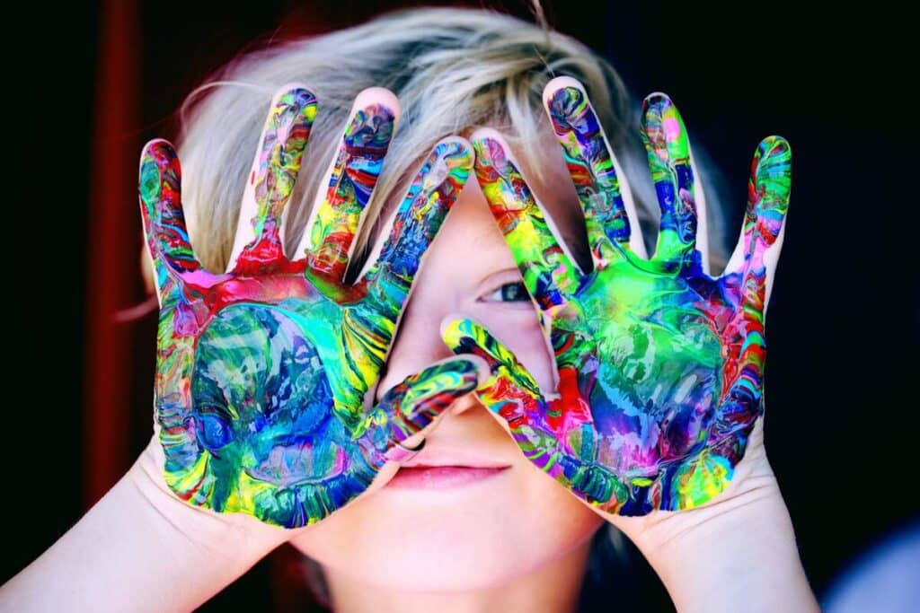 Boy holding his hands up to his face with paint all over them for February Half Term Events In Kent blog round up